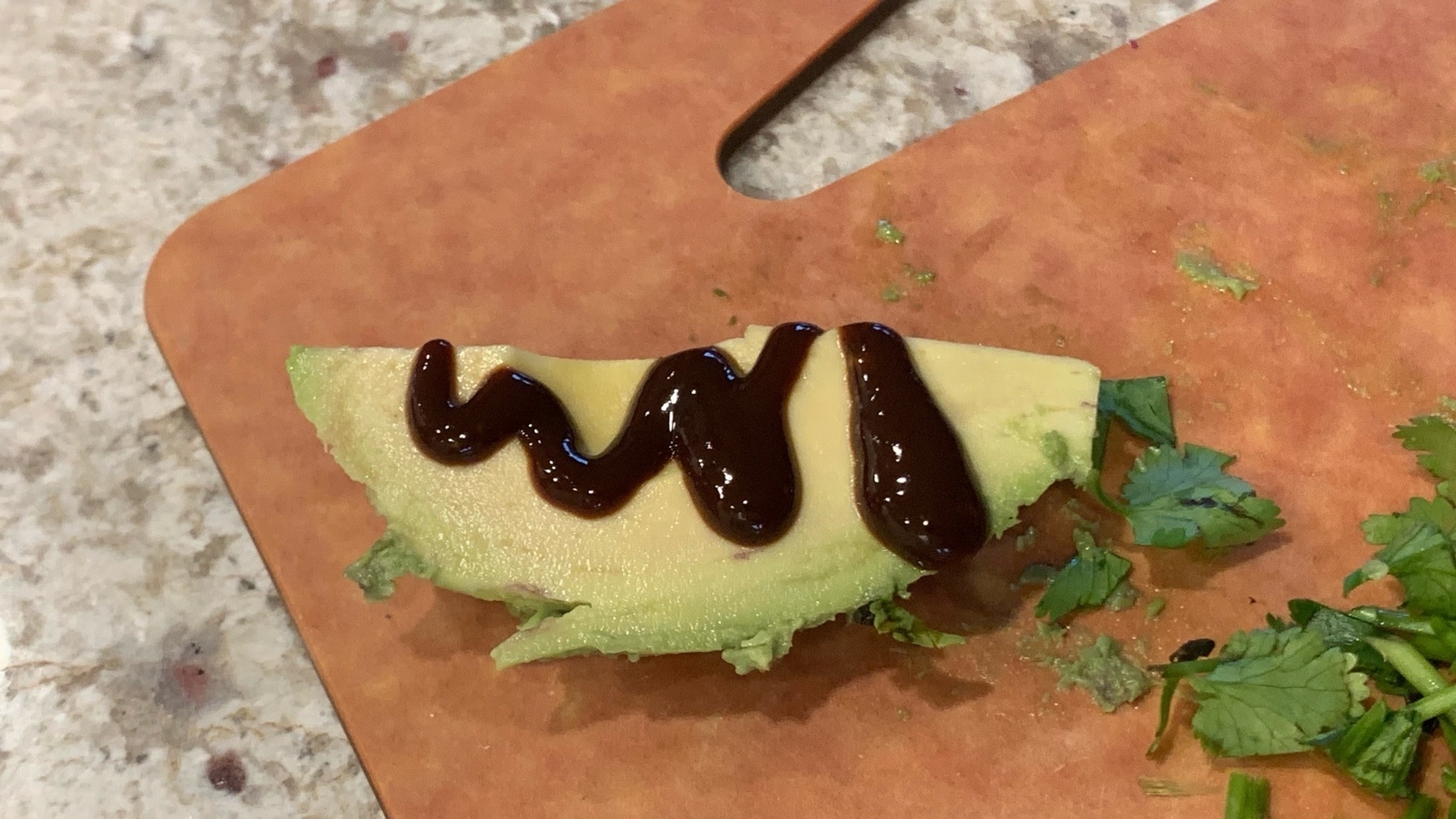 avocado with hot sauce on it